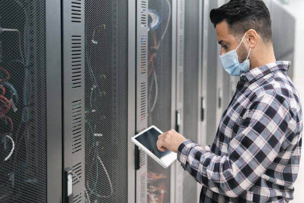Male informatic engineer working inside server room database whi